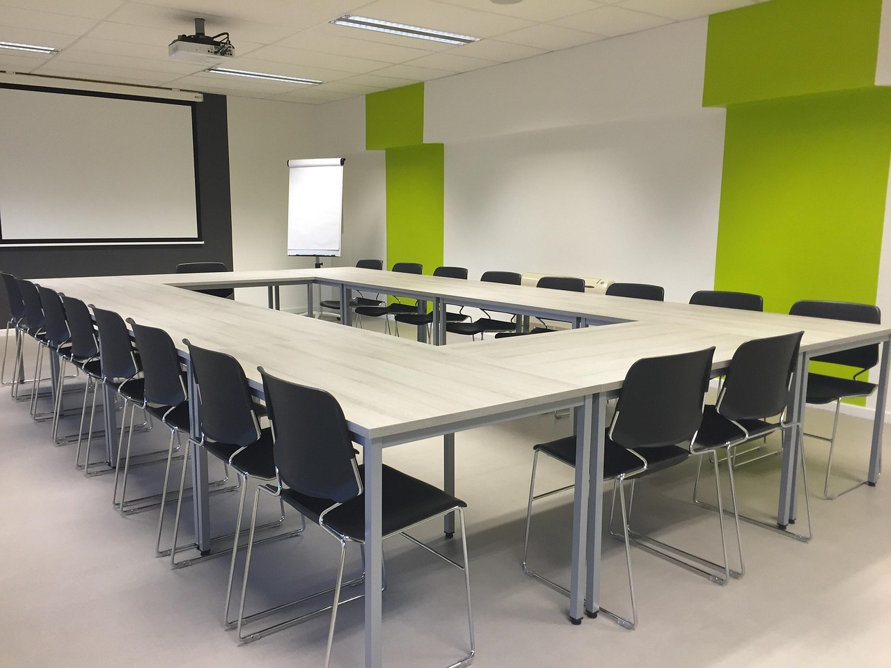 Facilitators reviewing printed architecture diagrams with markers on a wide table